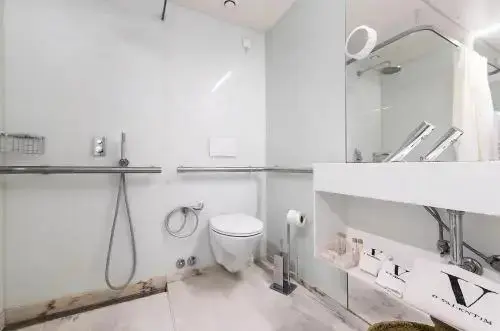 Une salle de bain claire avec douche à l'italienne et lavabo.