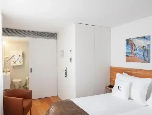 Une chambre lumineuse avec un lit et un accès à une salle de bain.