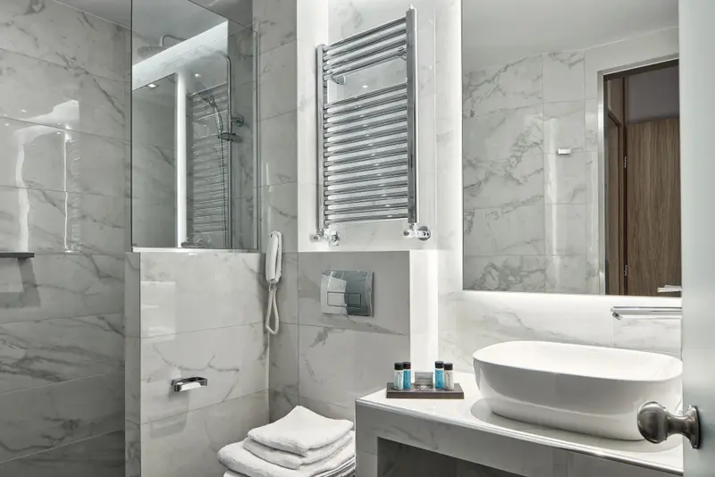Une salle de bain moderne avec des carreaux de marbre et des accessoires chromes.