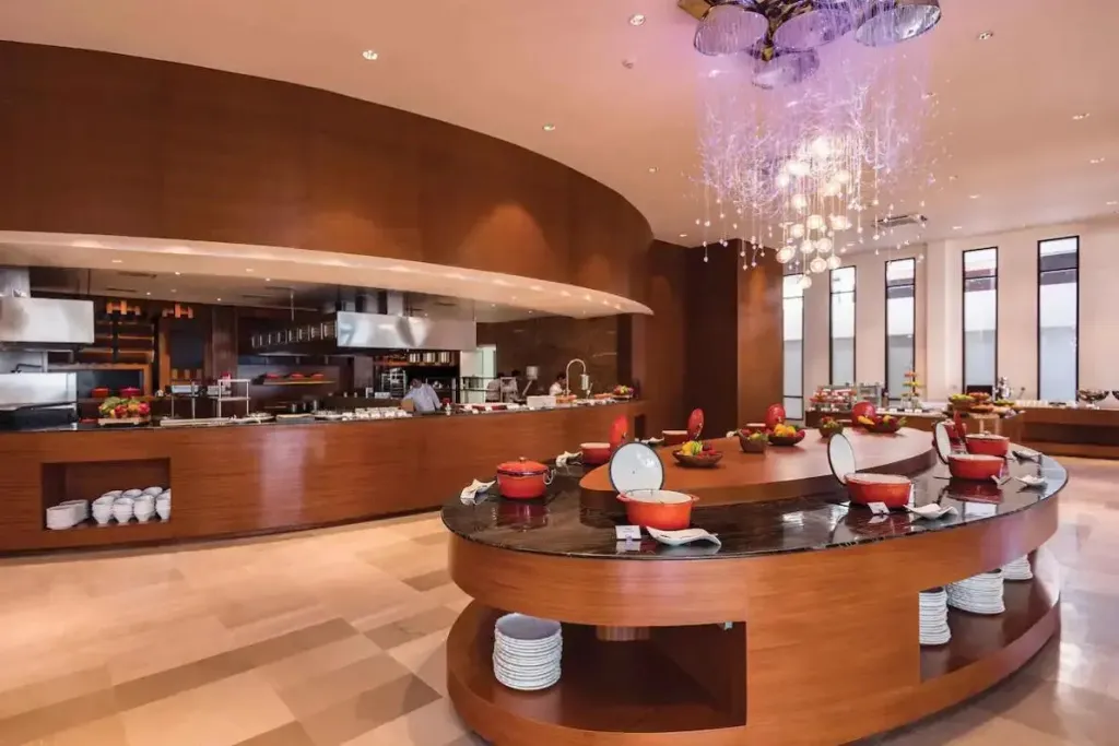 Un buffet de plats variés est présenté dans une salle lumineuse et moderne.