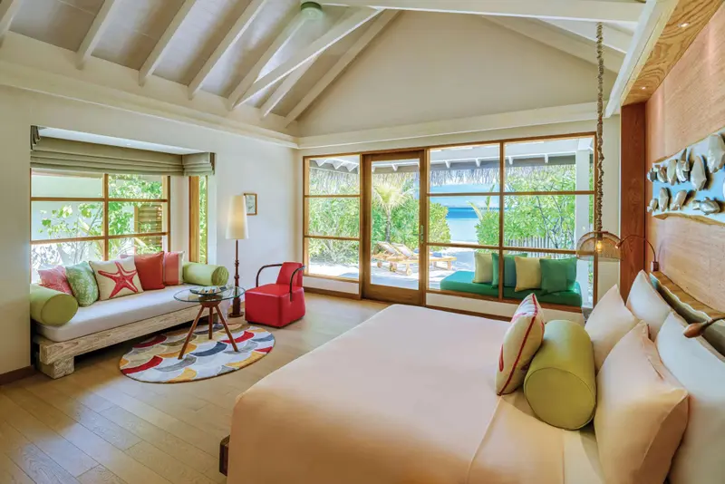 Une chambre lumineuse avec un grand lit et un espace détente.
