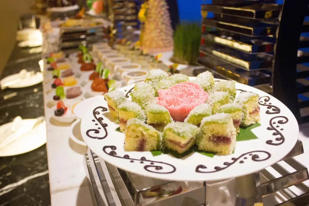 Assortiment de pâtisseries colorées présentées sur un buffet.