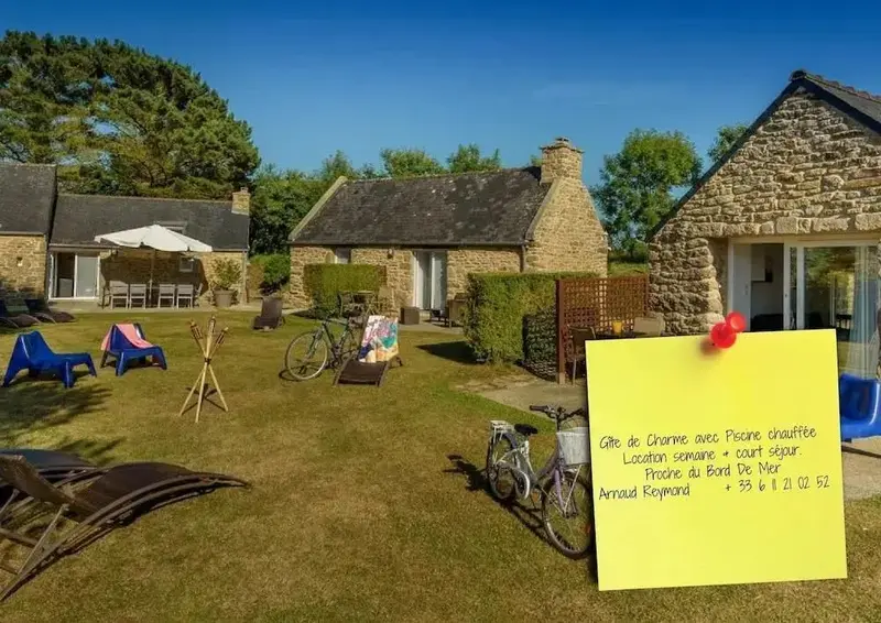 Maisons de campagne avec pelouse, transats et vélos dans un jardin ensoleillé.