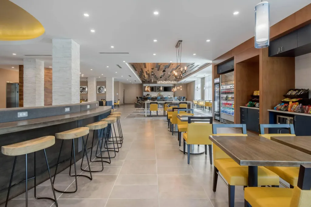 Une salle lumineuse avec un comptoir de bar et des tables à manger.