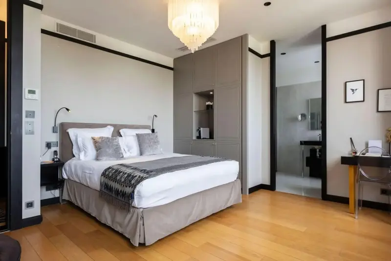 Une chambre lumineuse avec un grand lit et un espace bureau.