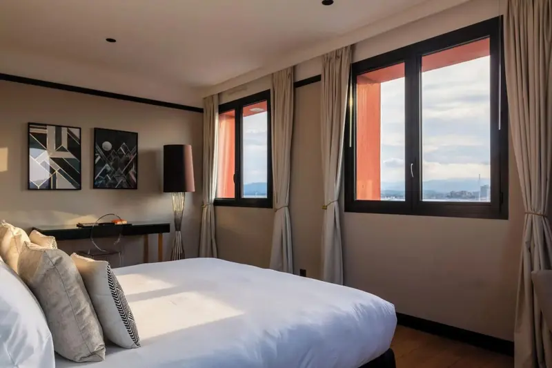 Une chambre lumineuse avec un grand lit et une vue sur le paysage.