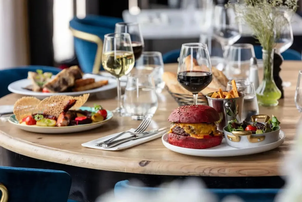 Une table ronde est dressée avec plusieurs plats et boissons.