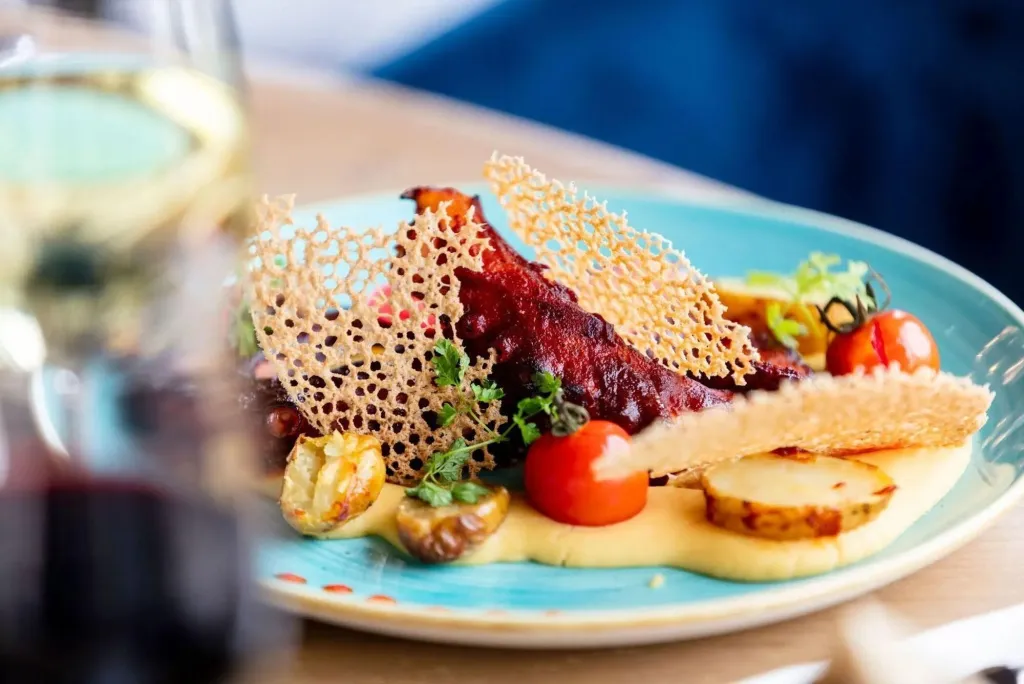 Assiette raffinée avec une préparation à base de poisson, de légumes et d'une sauce crémeuse.