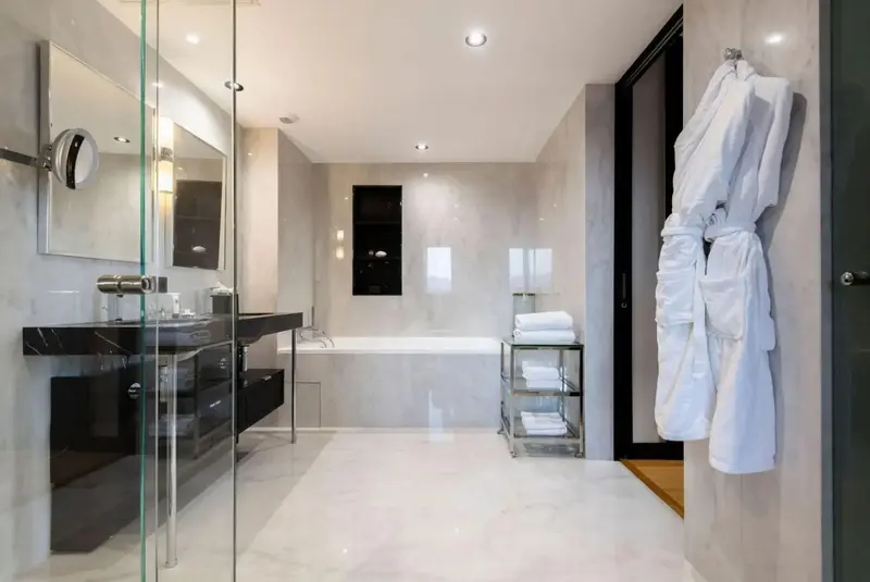 Une salle de bain moderne avec baignoire et vasque en marbre.