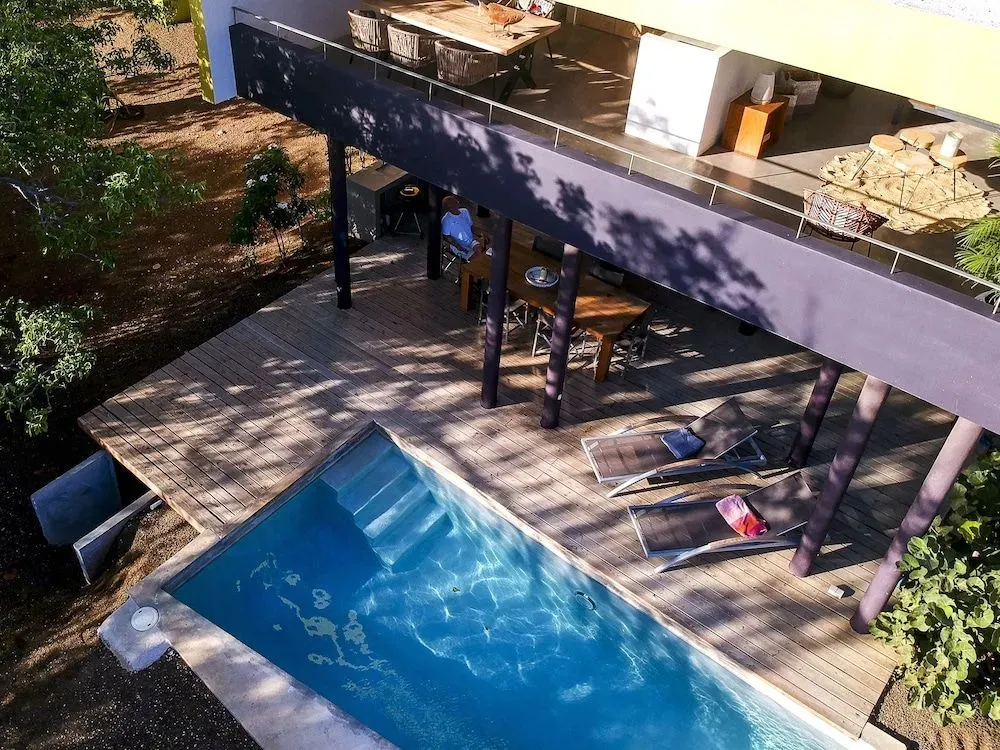 Terrasse en bois avec piscine et mobilier de détente.