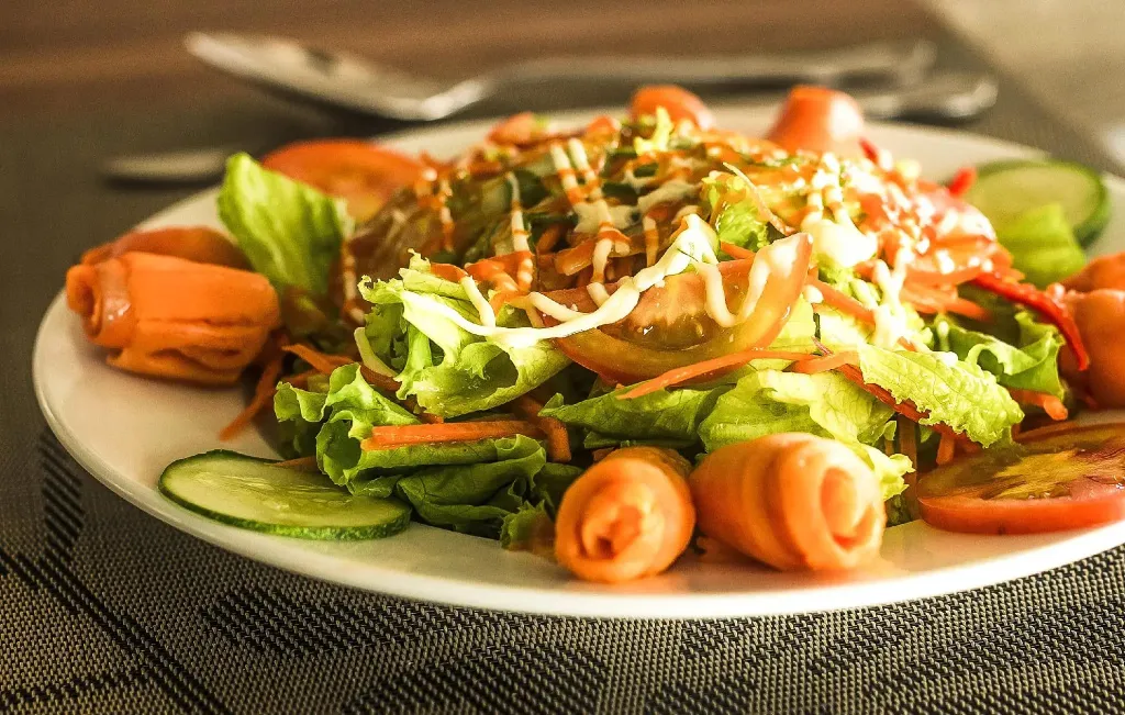 Une assiette de salade fraîchement préparée est présentée sur une table.
