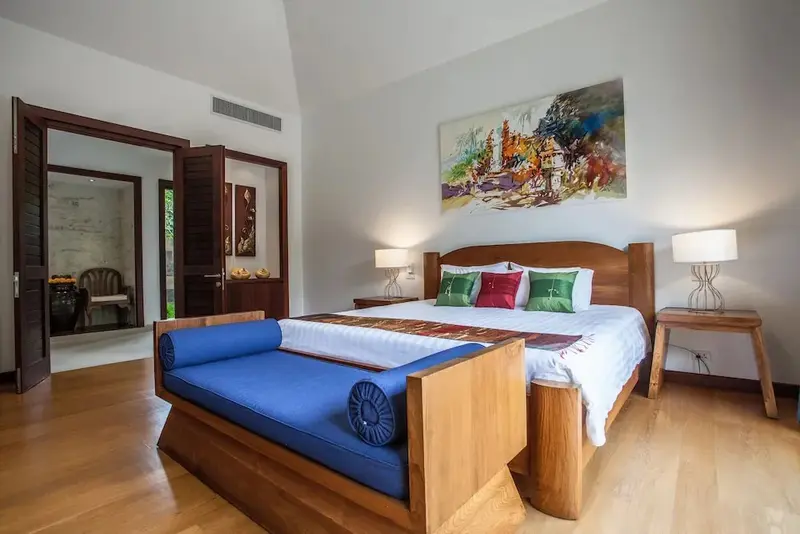 Une chambre lumineuse avec un grand lit et un canapé intégré.