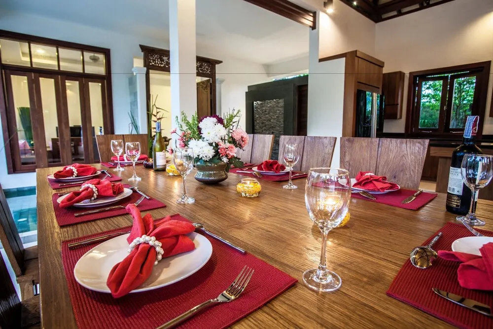 Une table de repas est dressée avec des couverts et des verres.