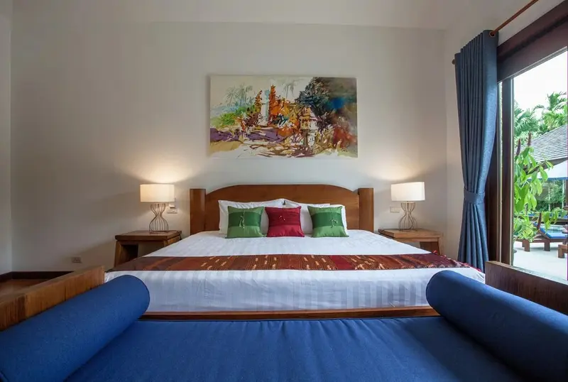 Une chambre lumineuse avec un grand lit et un canapé bleu.