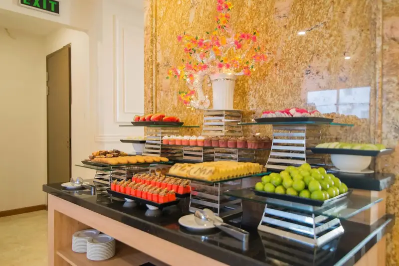 Un buffet propose une variété de pâtisseries et de fruits frais.