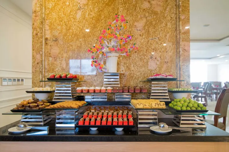 Un buffet propose une variété de pâtisseries et de fruits frais.