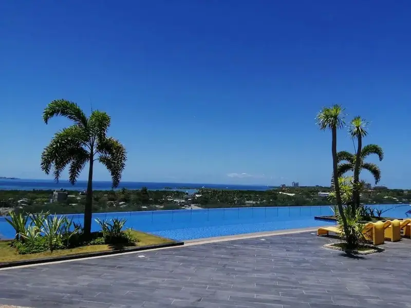 Une piscine à débordement offre une vue dégagée sur la mer et la végétation luxuriante.
