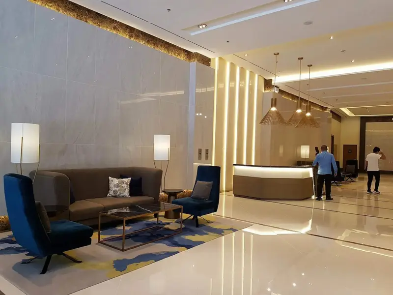 Un hall d'accueil lumineux avec un canapé et des fauteuils.