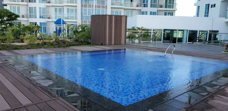 Une piscine rectangulaire bordée d'une terrasse en bois.