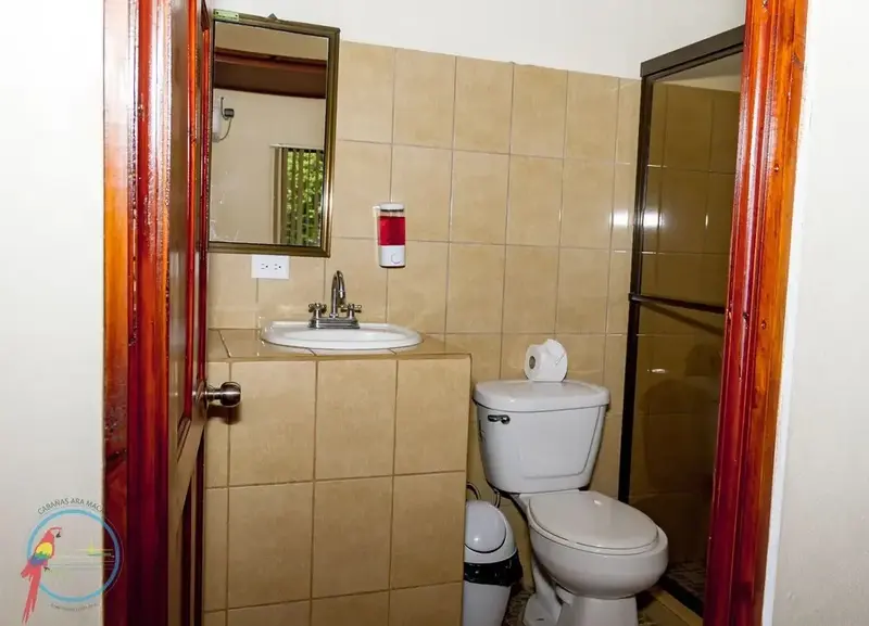 Une salle de bain carrelée avec lavabo, miroir et douche.