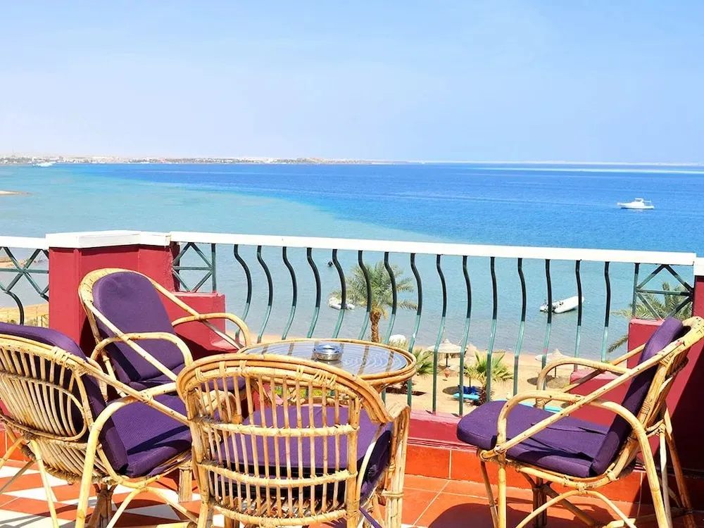 Terrasse aménagée avec mobilier en rotin donnant sur la mer.