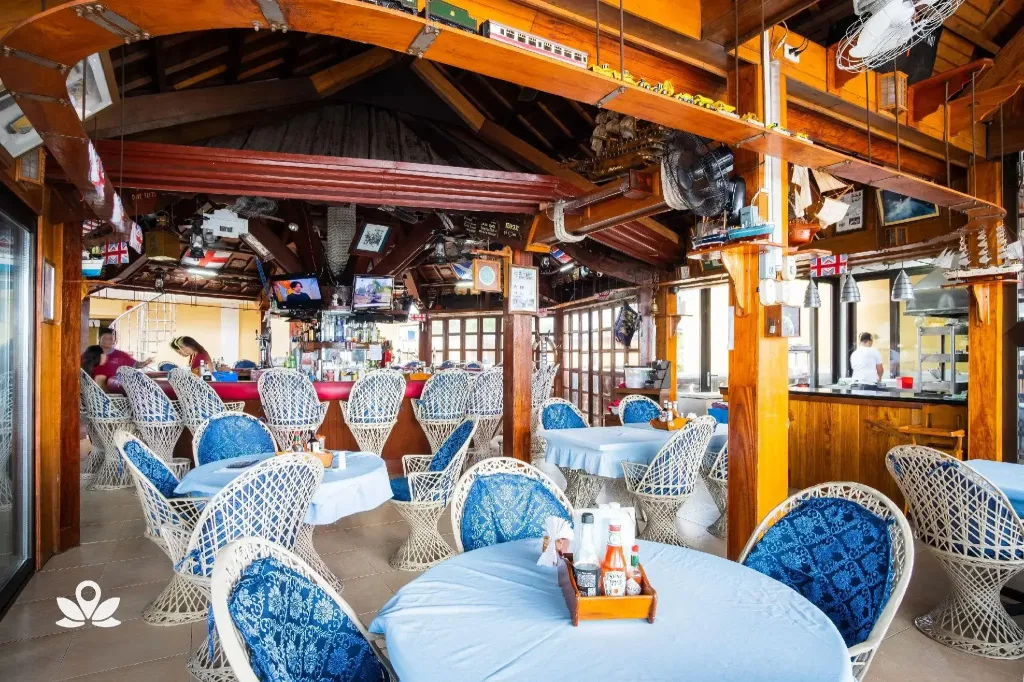 Une salle de restaurant lumineuse avec des tables et des chaises en osier.