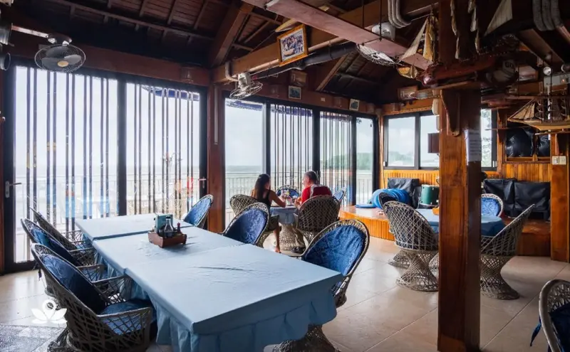 Une salle à manger lumineuse offre une vue sur la mer à travers de larges baies vitrées.