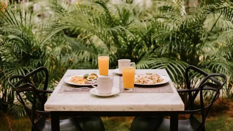 Une table est dressée pour le petit-déjeuner avec des plats et des boissons.