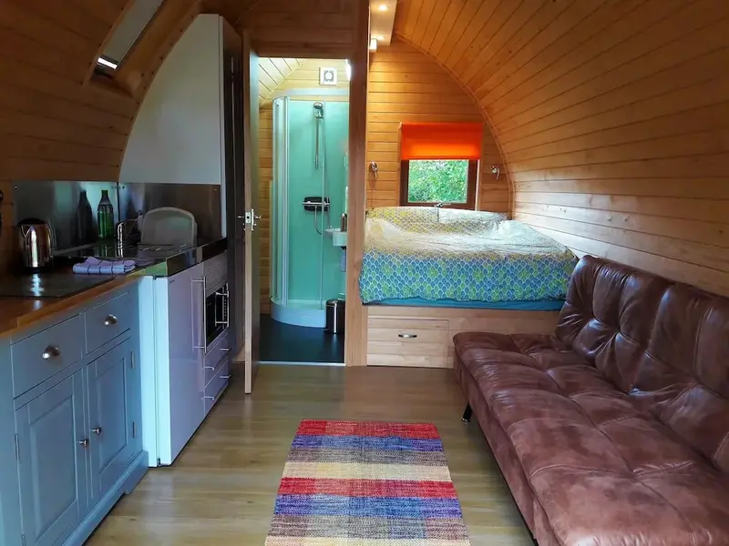 Intérieur chaleureux d'un logement avec cuisine, coin salon et chambre à coucher.