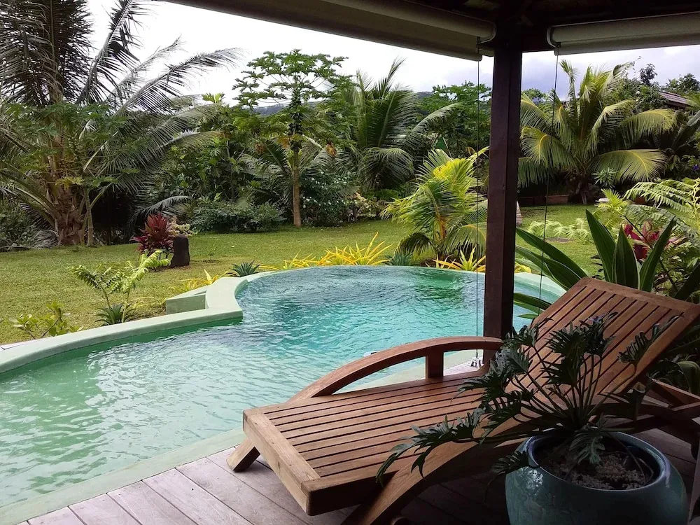 Une piscine turquoise invite à la détente dans un cadre tropical luxuriant.