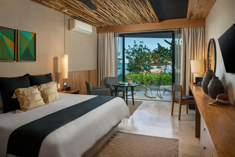Une chambre lumineuse avec un grand lit et un accès à une terrasse.