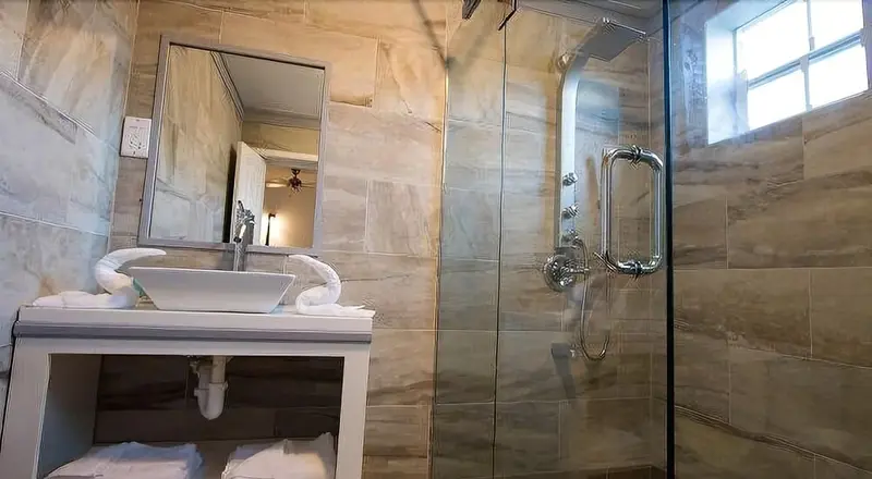 Une salle de bain moderne avec douche à l'italienne et vasque sur meuble.