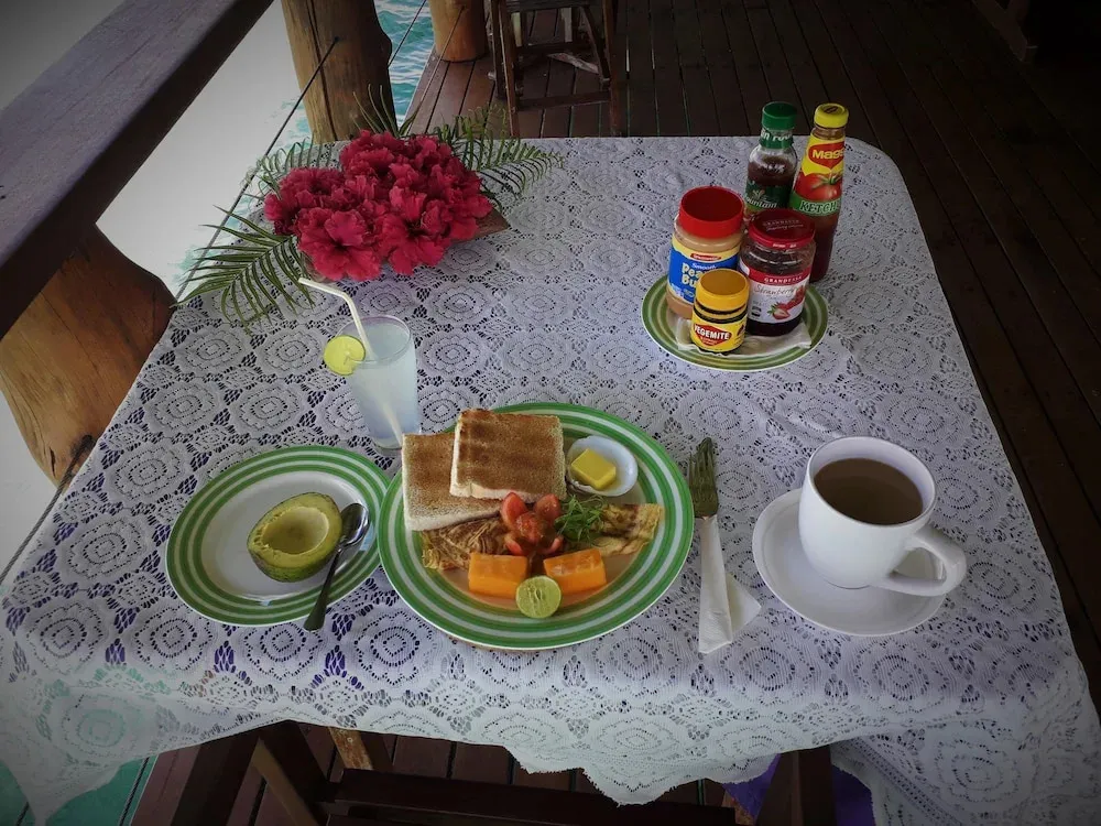 Une table est dressée avec un petit-déjeuner composé de fruits, d'œufs et de pain.