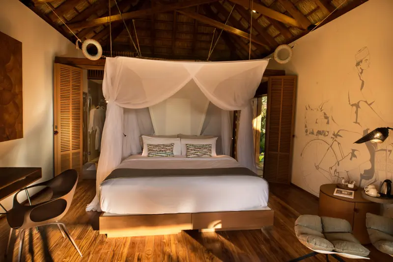 Une chambre lumineuse avec un lit à baldaquin et une décoration murale.