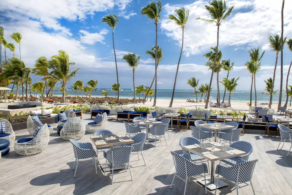 Terrasse de restaurant avec tables et chaises en bord de mer.