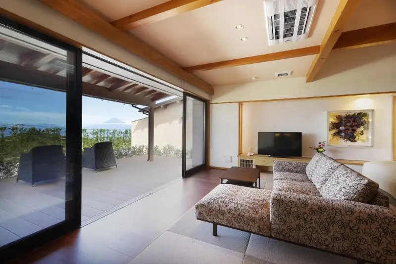 Espace de vie lumineux avec canapé et accès à une terrasse offrant une vue sur la mer.