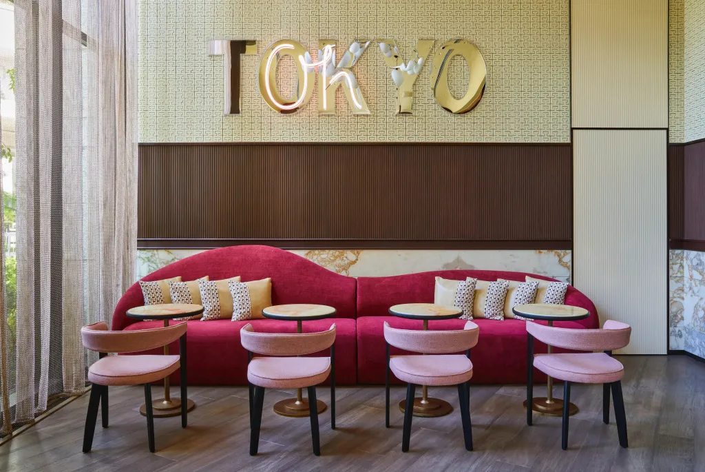Un espace de détente avec un canapé rouge et des fauteuils roses.