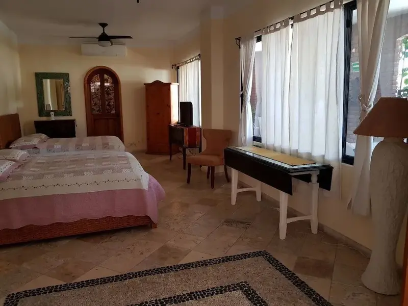 Une chambre lumineuse avec un grand lit et un bureau.