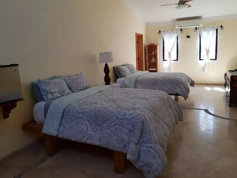 Une chambre lumineuse avec deux lits recouverts de motifs.
