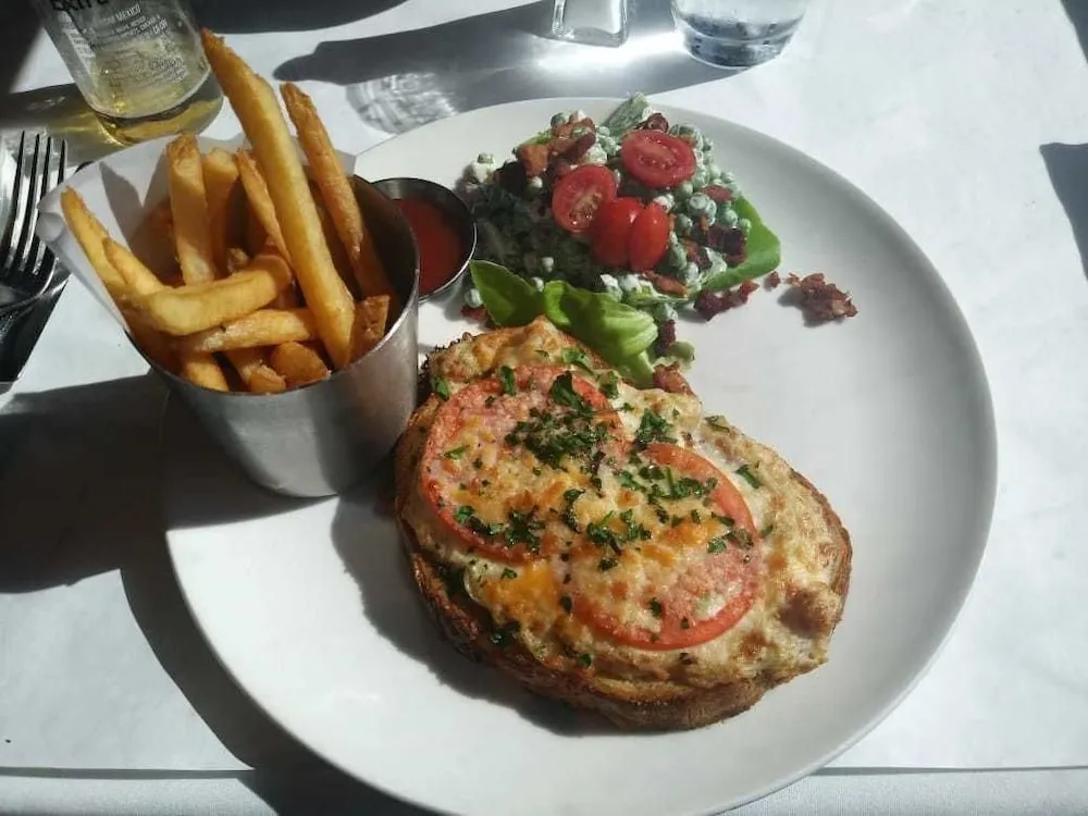Assiette copieuse avec plat principal, salade et accompagnement de frites.