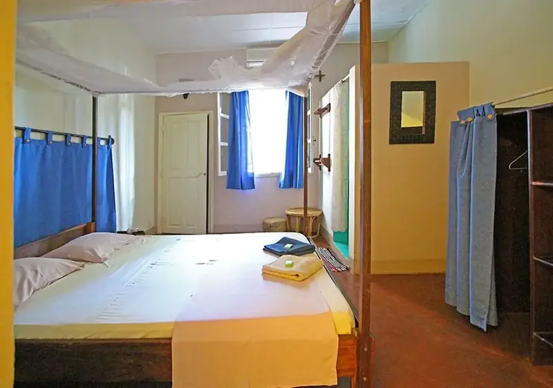 Une chambre lumineuse avec un lit recouvert d'une moustiquaire.
