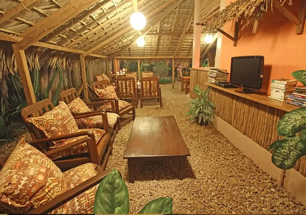 Espace de détente intérieur avec mobilier en bois et sol en gravier.