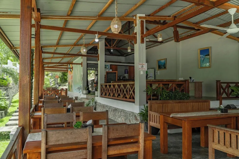 Une salle de restaurant à l'abri sous une toiture en bois et métal.