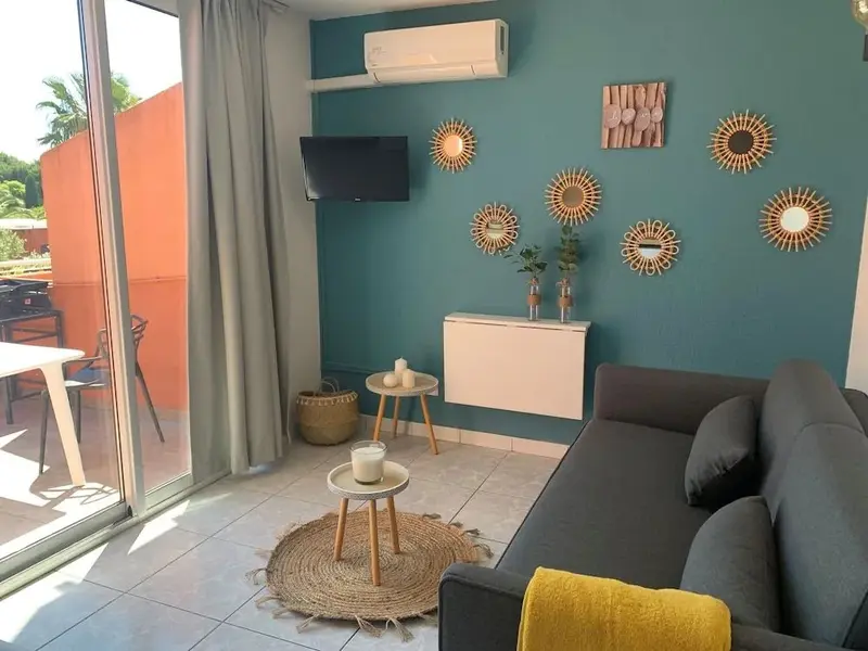 Un salon lumineux avec un canapé gris et des décorations murales solaires.