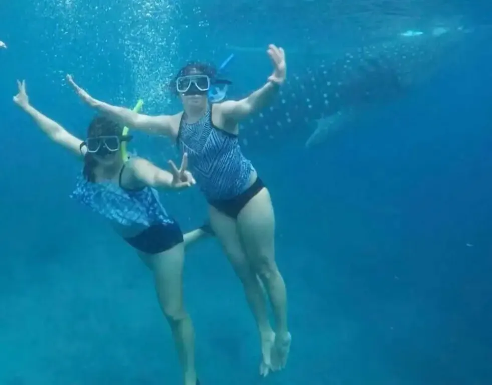 Deux personnes nagent en surface avec masque et tuba dans une eau turquoise.