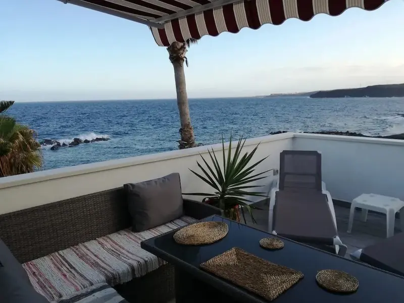 Terrasse aménagée avec salon et table basse donnant sur la mer.