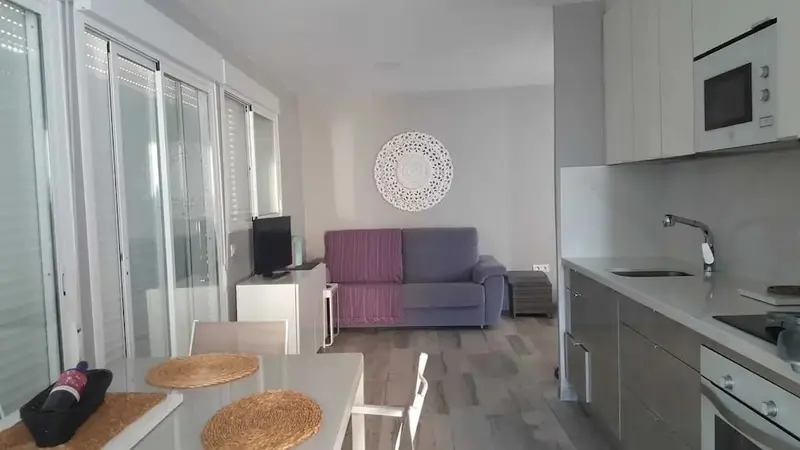 Espace de vie lumineux avec coin repas et cuisine équipée.
