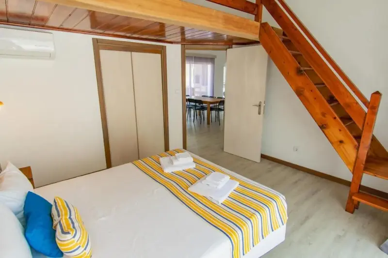 Une chambre lumineuse avec un lit décoré de coussins et de serviettes.