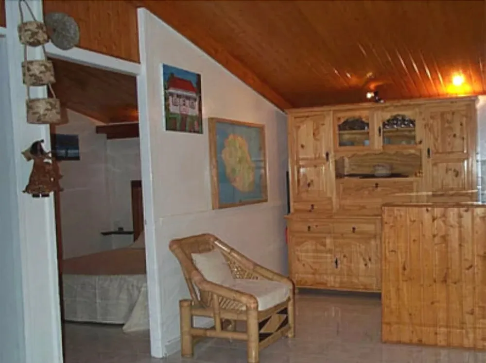 Une pièce lumineuse avec un coin salon et un buffet en bois.