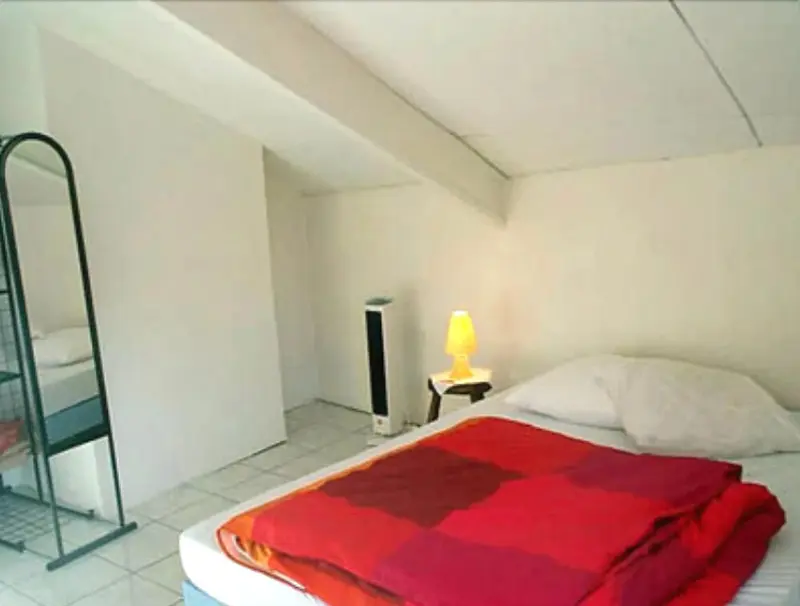 Une chambre lumineuse avec un lit recouvert d'une couverture à carreaux.